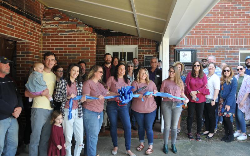 Megan McCurley joins a large Hartwell contingency and cuts the ribbon on the new Doula at Hart office at 236 W. Franklin Street.