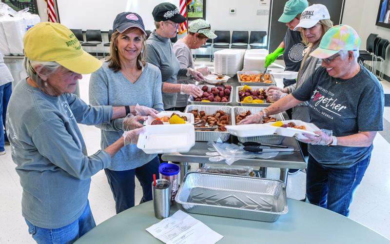 Kate Kirby, Brigid Richardson, Marylynn Johnson prepare plates for drive-through customers.