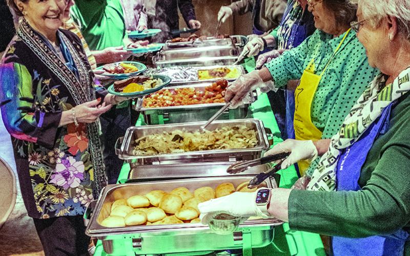 Pictured right, Sacred Heart members and visitors plate up their meals.