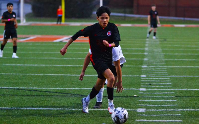 Luis Genchi takes on several defenders before scoring a goal against Crescent.