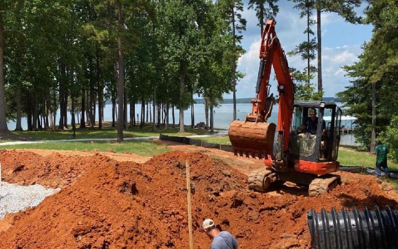 Sidney Skelton and crew members prepare the ground to install a new septic tank.