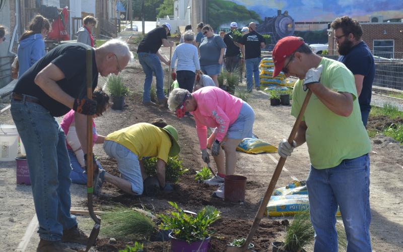 Volunteers help plant at the Railroad Street Park last week.