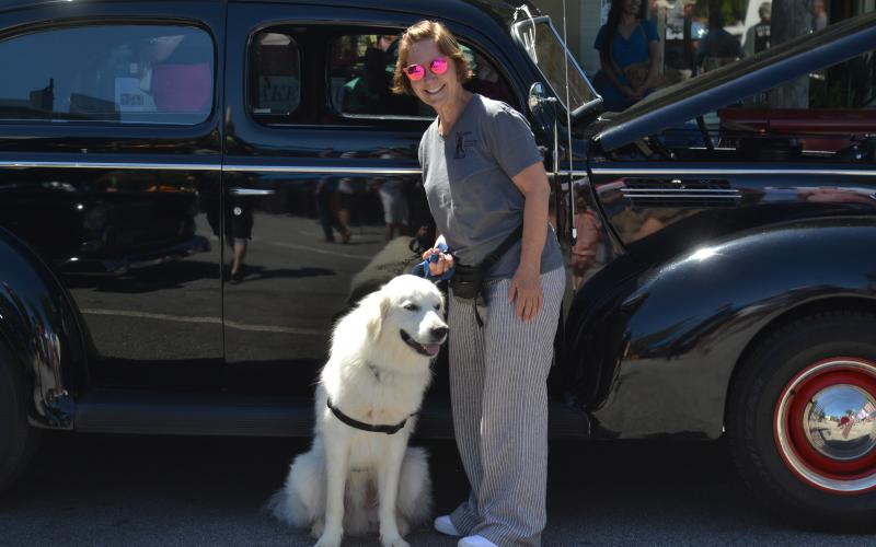 Dan Hunt/The Hartwell Sun - Lynn Essert and dog Milo stand alongside one of the 1940’s era cars present at this year’s car show. Milo was one of several pets up for adoption by the Hart County Humane Society.