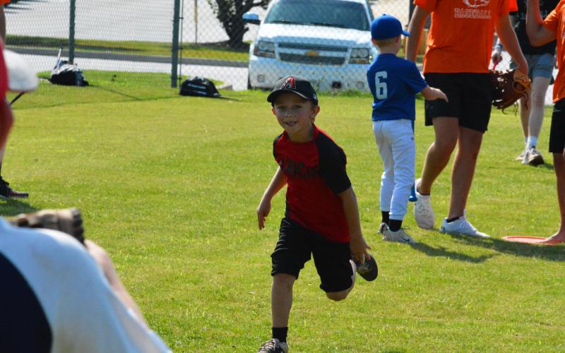 Rhett McGowen runs to first after getting a hit at baseball camp last summer.