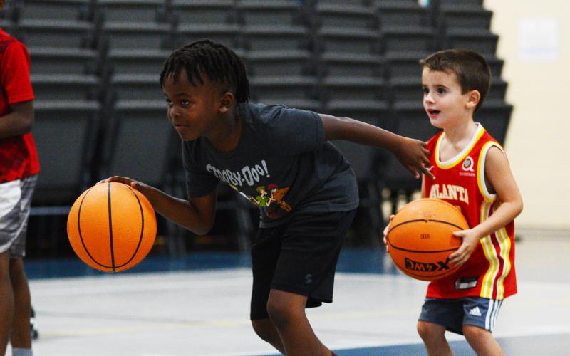 Corbyn White (left) and Korbin Cawthon, the youngest camper, work on their dribbling skills in a game of red light, green light.