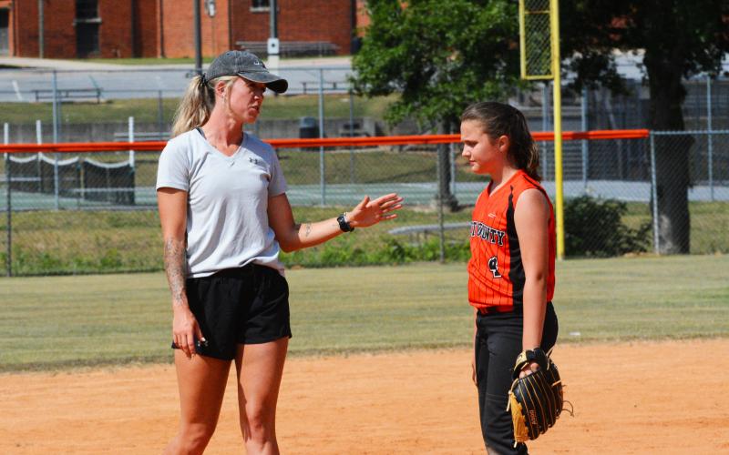 HCMS coach Kim Thomas gives EmmaKate White some pointers to improve her pitching.