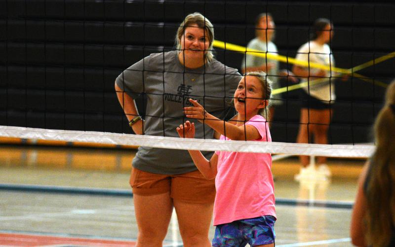 Head volleyball coach Kate Beardsley works one-on-one with camper Andie Jane Holmes.