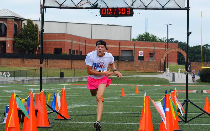 Zachery Benner stumbles past the finish line to finish first overall in the Historic Hartwell 5K on June 2.