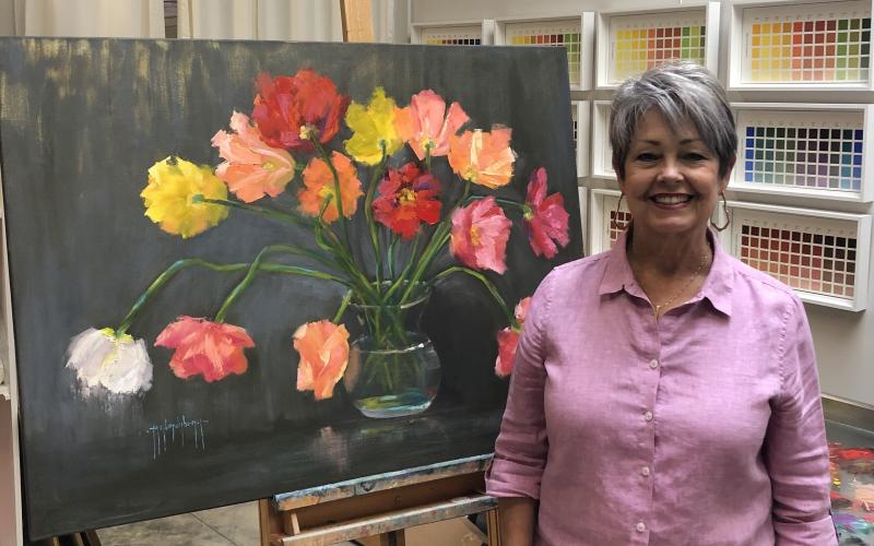 Debra Taylor, a.k.a. Taylor Dubeau, alongside one of her original paintings “Happy Explosion.” Taylor will have a full exhibit of original oil paintings on exhibit at the Hartwell Art Center beginning July 28.