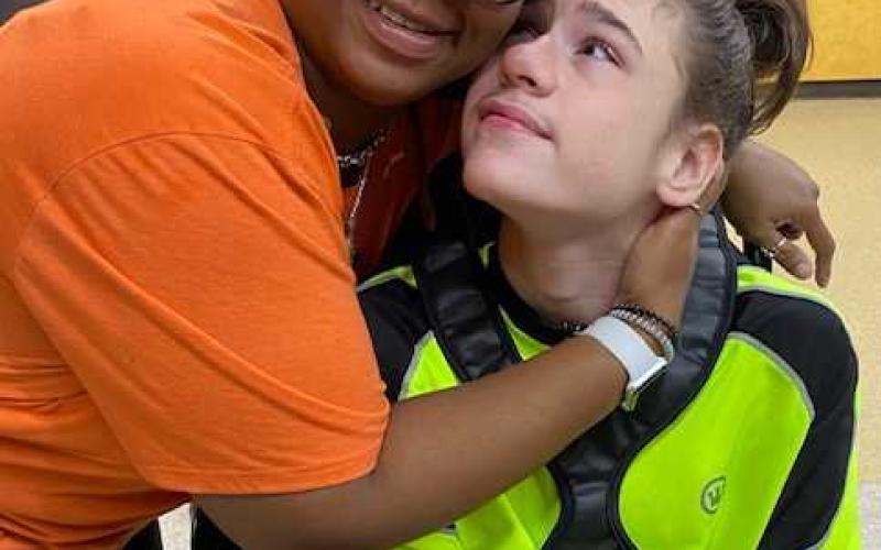 Volunteer Tankika Thrift and Khristion Henderson share a hug.