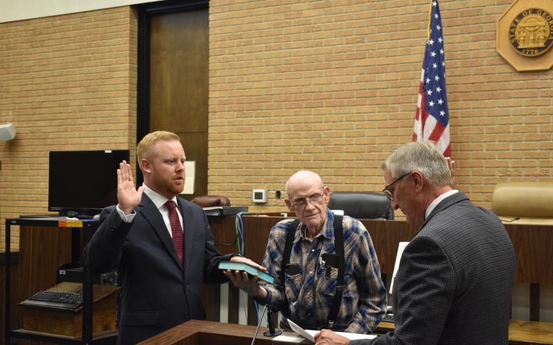Jeff Brown, left, takes the oath of office on Aug. 10 alongside his grandfather Dale Banister, middle, and judge Jeffrey Malcom. Brown, who won the Republican primary for District 4 on the Hart County Board of Commissioners, was sworn in early following his predecessor’s resignation.