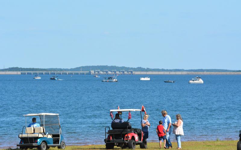 Interested spectators watch from golf carts near Sanders Circle in Hartwell, as a multi-agency plane and body recovery unfolds before them on Thursday, Sept. 15.