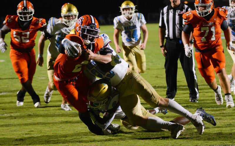 Paul Davis extends the ball over the goal line as multiple Daniel defenders try to bring him down.