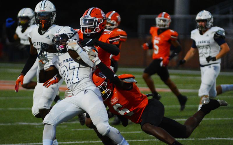 Keith Curry (11) and Jamir Rucker (6) bring down a St. Francis ball carrier in the win on Sept. 16.
