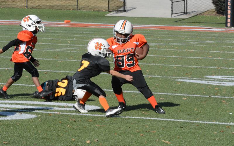 Hart County 8U defenders Ramsey Beggs (58), Carter Allen (12) and Corbyn Swann pursue a Rabun County ballcarrier during Hart County’s 13-0 win.