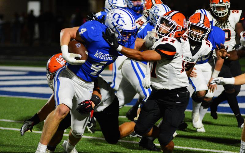 Na’tayvious Martin wrestles down Oconee County’s star player, Whit Weeks, on a goal line play on Oct. 7.