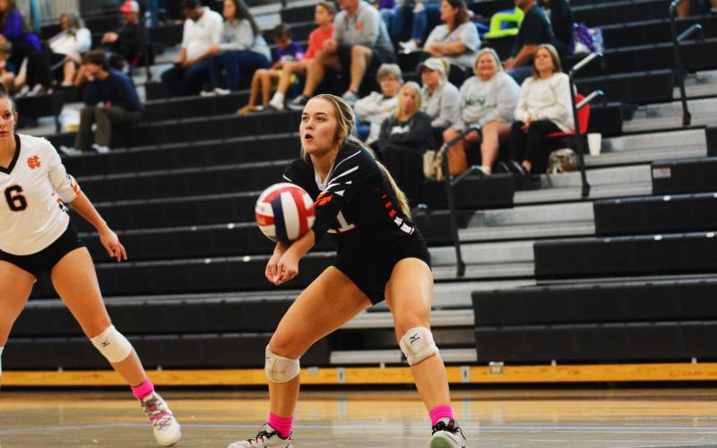 Left, Dakota Phillips tries to get past Oconee County blockers on Tuesday, Oct. 4. Right, Abby Hubbard gets the dig in the Dig Pink tournament on Oct. 1.