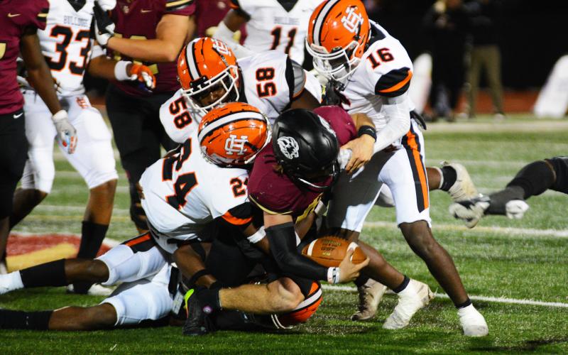 A pack of Bulldog defenders bring down the talented Hebron Christian quarterback.