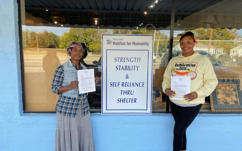 Hartwell residents Rebecca Durrett, left, and Brittany Harland, right, pose with their initial partner family agreement certificate with Hart County Habitat for Humanity building. Durrett and Harland were selected among several applicants for the newest home builds.