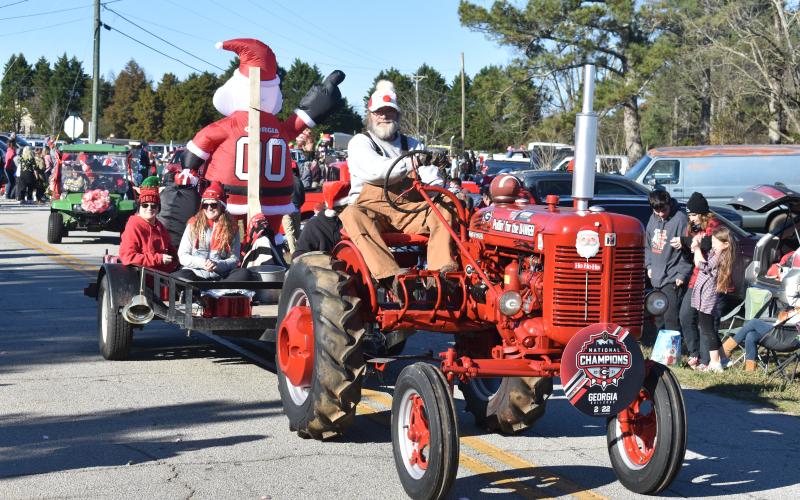 A gentleman takes his tractor along Montevideo Road Sunday at the annual Montevideo Christmas parade.