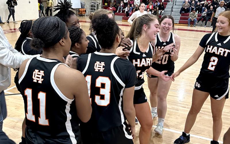 The Lady Dogs basketball team swarm their teammate Phillips in the aftermath of her high school scoring achievement.