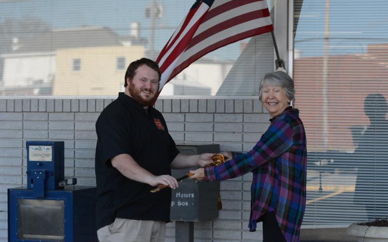 Joyce Kilpatrick (right) presents Hartwell resident Sam Simpson (left) with a Navy officer ceremonial sword that originally belonged to his late grandfather. Kilpatrick bought the sword at an auction before doing some investigating and returning it to its family.