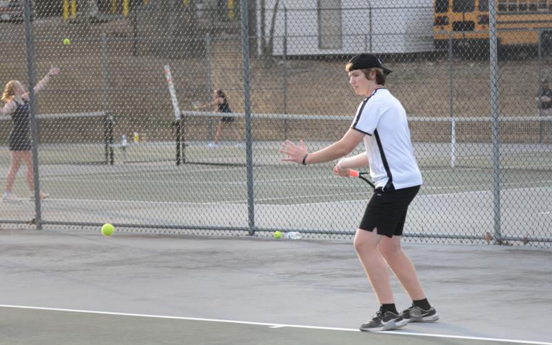 Justin Mooney returning a serve at a home match.