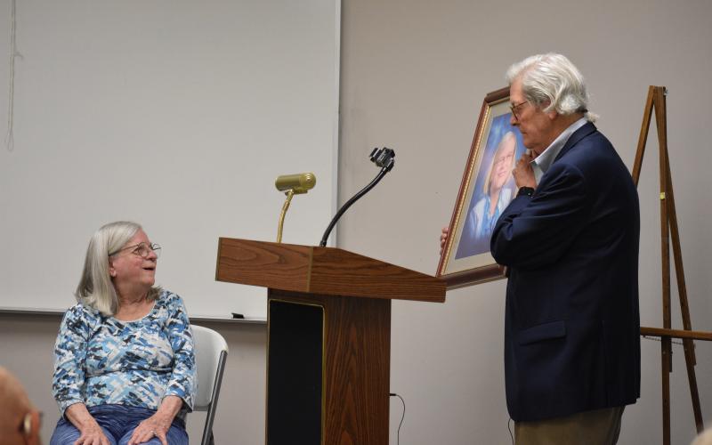 Emily Gunnells (left) is surprised as Walter Gordon unveils a portrait of Gunnells, which will hang in a place of prominence with the Hart County Adult Learning Center.