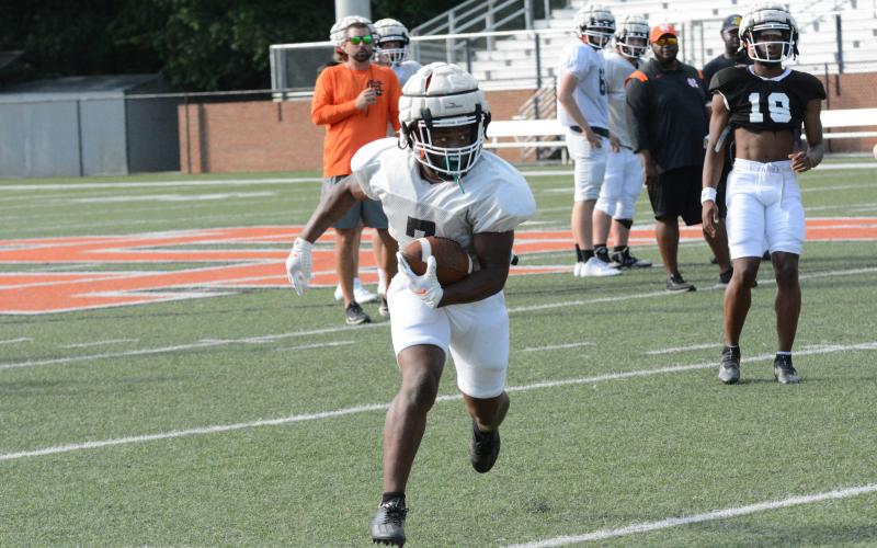 Rising senior running back Nori Moore looks to turn up the field in Monday’s spring practice .