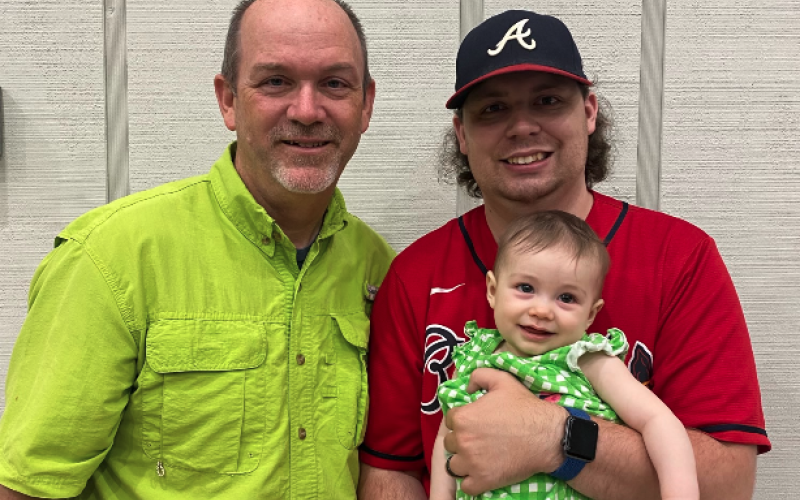 Todd London (left) stands next to his son Benjamin London (right), who is holding a very happy Baylor Kate.