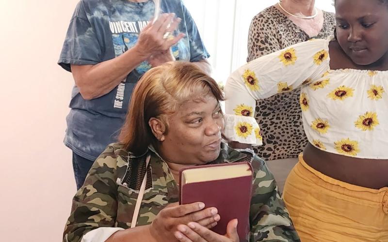 Above Yolanda Feaster has just received a new family Bible during the dedication ceremony in her new home.