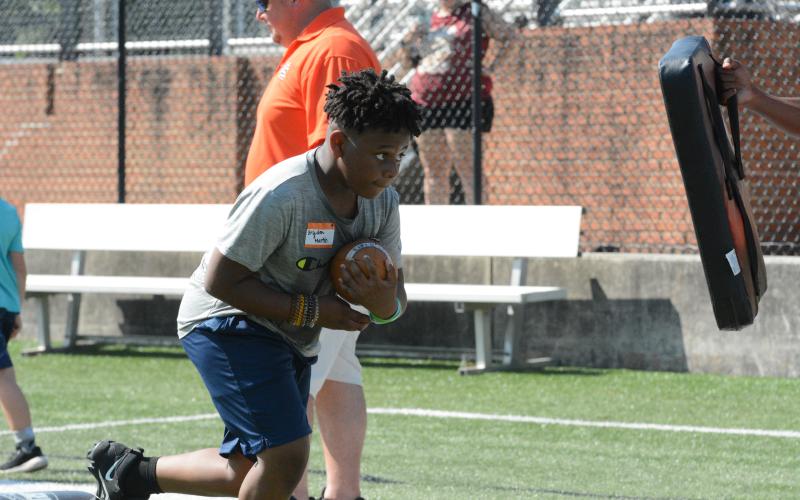 Pictured is Brydon Martin as he tucks the ball and prepares for contact in a running back drill during the camp in 2022.