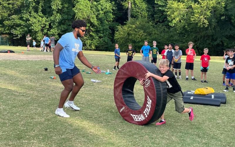 North Carolina Tar Heel football senior defender Kaimon Rucker serves at a youth football camp in Chatham County, NC in June of 2022. Photo by the University of North Carolina Athletics
