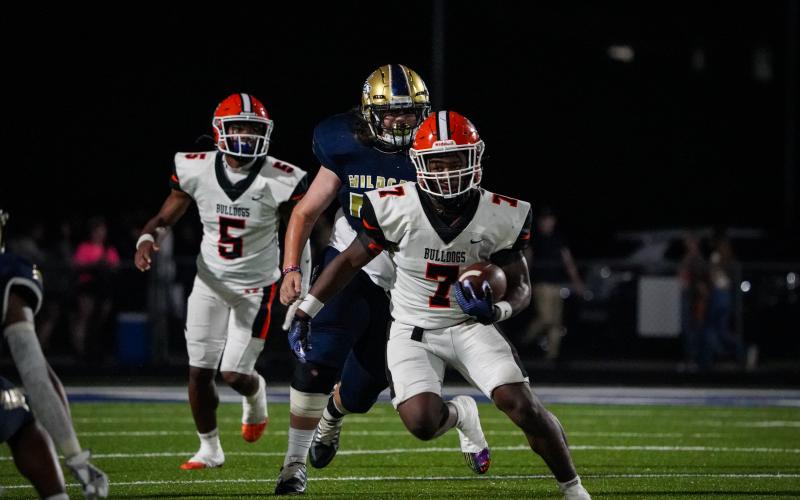 Senior quarterback Jashon Gaines (5) hands the ball off to senior running back Nori Moore who rushes in for the score in the Dogs 17-10 win over the Wildcats of Apalachee Sept. 1. (Photo by Lexie Wheless)