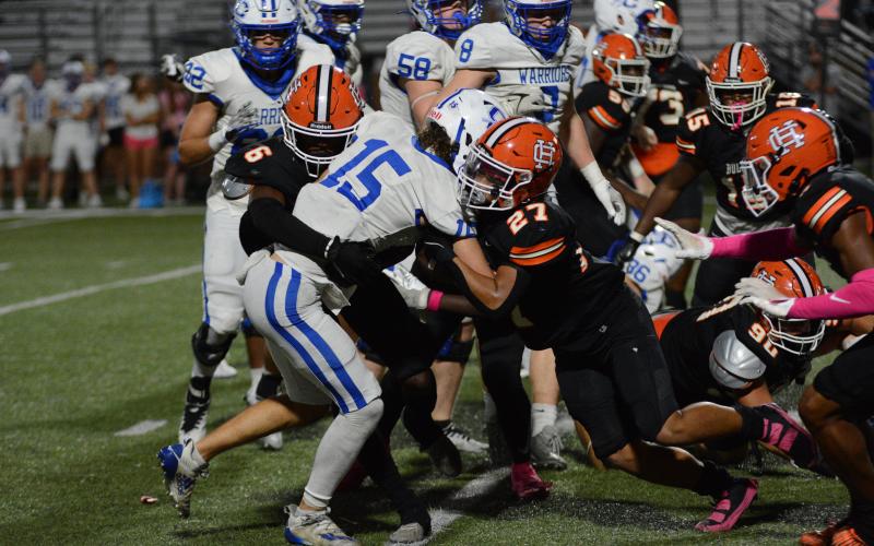 Jamir Rucker (6) and Tay Martin (27) tackle the Warriors quarterback in the 27-16 win.
