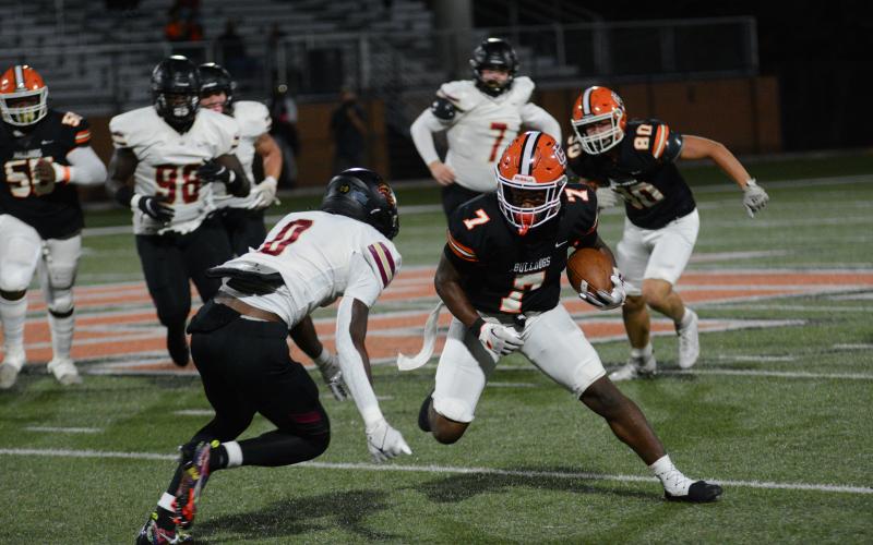 Senior running back Nori Moore attempts to juke the oncoming Hebron Christian defender in the 27-0 loss on Oct. 27.
