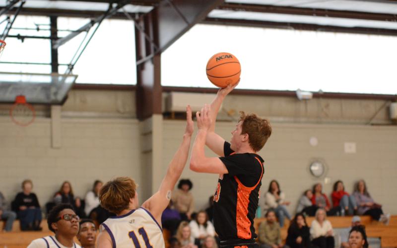 Pictured right is senior forward Avery Strickland hitting a jumper as he scored 11 points.