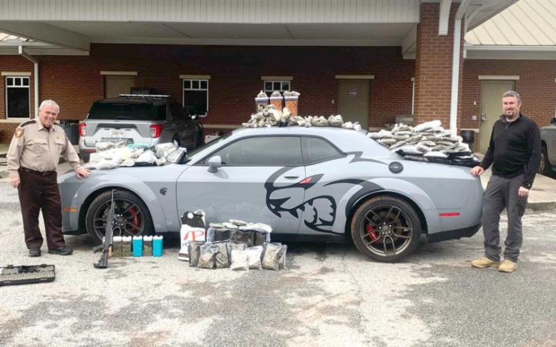 Hart County Sheriff Mike Cleveland (left) and Capt. Chris Carroll stand with the seized “Jail Break Hell Cat” Dodge Challenger, drugs and weapons. The Jan. 17 incident comes in at number six on our list.