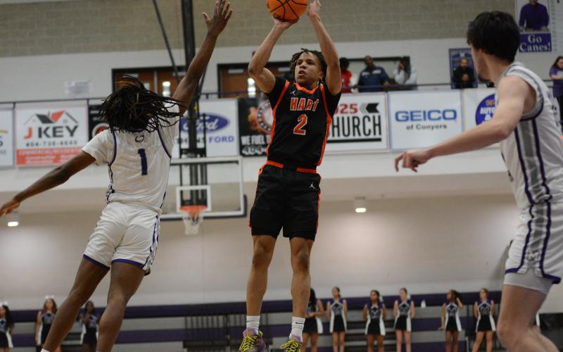 Junior guard O’Brian Evans knocks down a three pointer against the Purple Hurricane defender in the 70-66 road win to pick up Hart County’s first region win of the season.