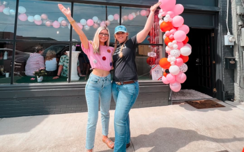 Owners of Happy Hounds Faith Phillips (left) and Breanna Shattles (right) celebrate the opening of their pet grooming business on Depot Street in Hartwell in May of 2023.