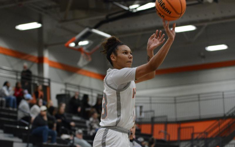 Senior forward Alexis Walker drains a three from the Ensley-McCurley Court logo in the 48-40 win over Dawson County.