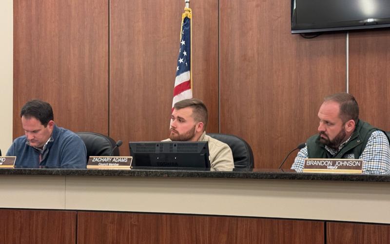 Council members (from left to right) Dan Leard, Zach Adams, and mayor Brandon Johnson hear debate on local alcohol license