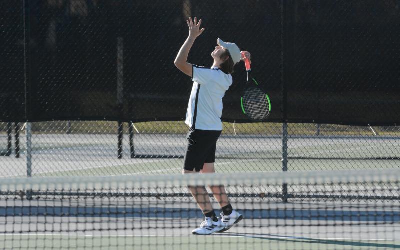 Senior No. 1 singles Justin Mooney prepares to serve the ball during the 2023 season.