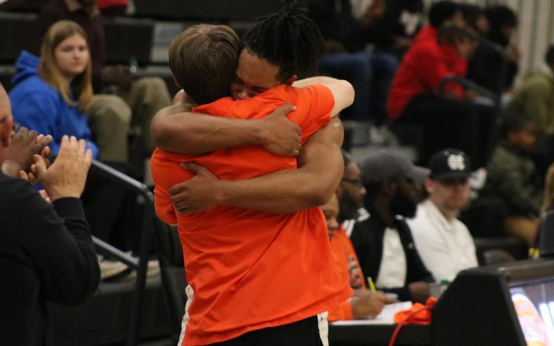 Senior forward Micah Reese hugs Dogs head coach Matt Gibbs as Reese checks out for the final time as a Bulldog. Photo by Grayson Williams/Hart County Charter System