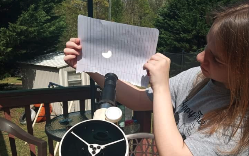 Hartwell native Josie Carter uses her Explore First light 114mm Newtonian Reflector Telescope with Twilight Nano to show where the moon is covering the sun.