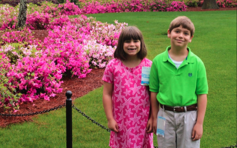 Right before the rains came, Vivian Fargason (left) and her brother Reid pose for a picture in front of the Augusta National clubhouse on April 9, 2019.