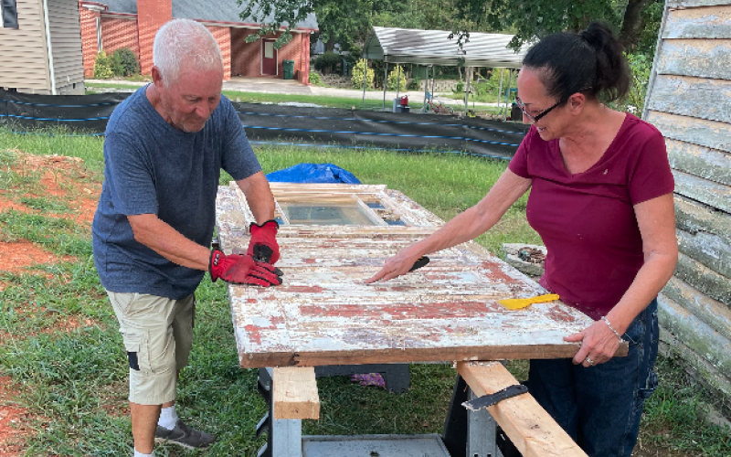 Lori Smith and her father, Richard, scraping paint off the front door from an E. Howell St. historic house last year.