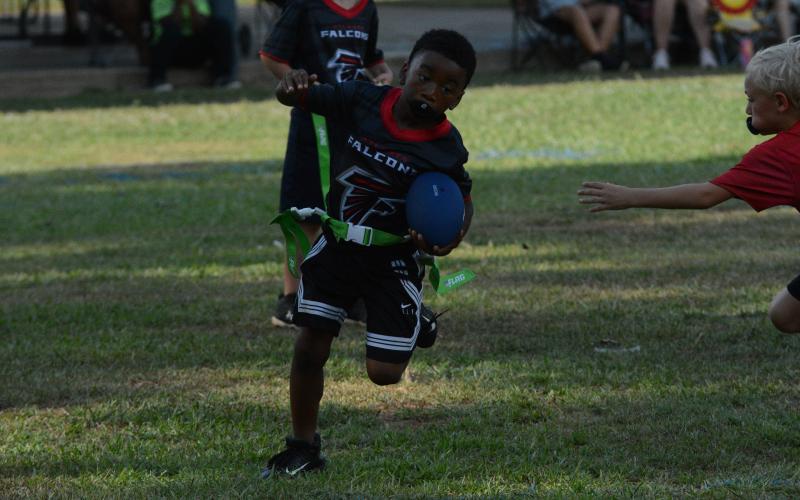 Pictured is Daniel Lewis as he picks up a chunk of yards on the run play during the inaugural season opener of NFL FLAG football at the Bell Family YMCA on July 15.