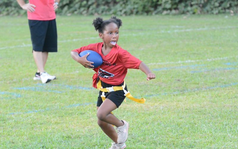 Pictured is Aydens Sanders as she rushes to the right sideline en route to score a touchdown at the NFL FLAG season opener.