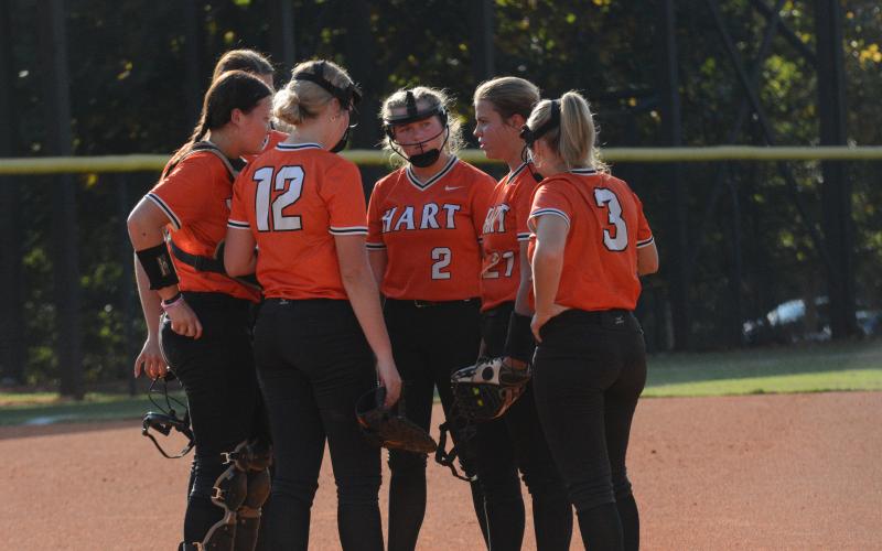 The Lady Dogs meet at the mound during a seven run second inning in the 15-0 run rule against the Lady Wolverines of Prince Avenue Christian on Sept. 24.